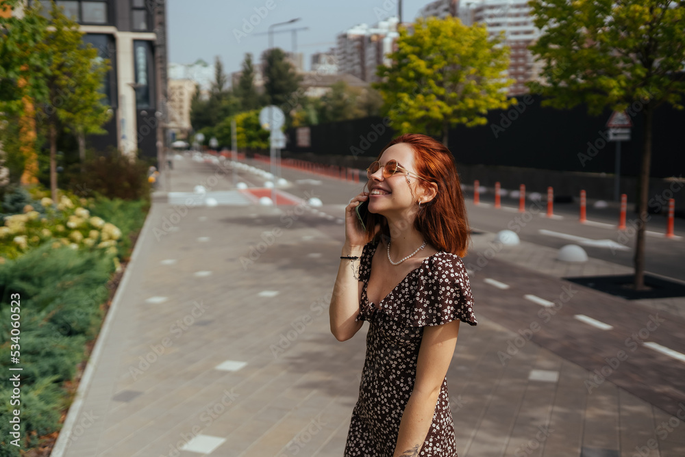 Cute girl talking on mobile phone on modern city background