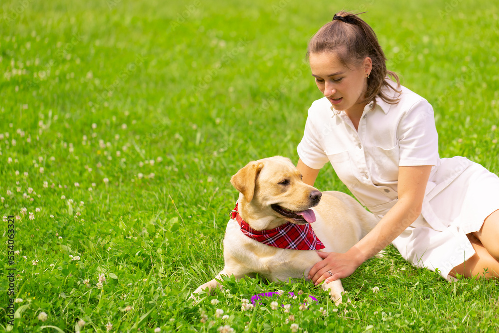 Young woman with her cute yellow labrador outside. Lovely pet, animal love concept Young woman with her cute yellow labrador outside. Lovely pet, animal love concept