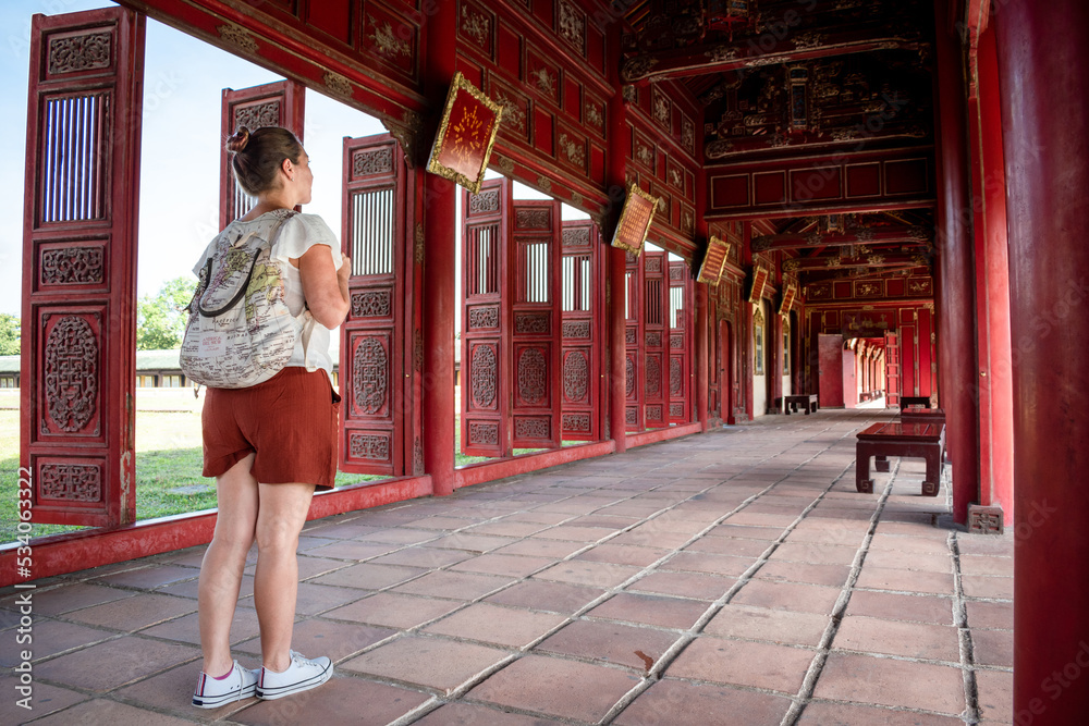 Mujer turista descubriendo los pasillos y corredores de la antigua ciudad imperial de Hue Mujer turista descubriendo los pasillos y corredores de la antigua ciudad imperial de Hue