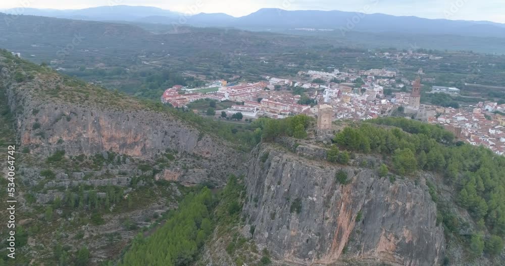 Cadena montañosa junto a villa valenciana con castillo en ruinas Cadena montañosa junto a villa valenciana con castillo en ruinas