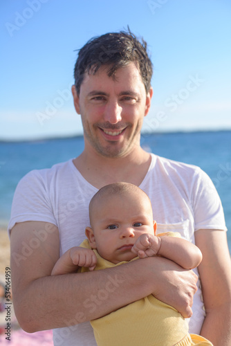 Father holding his baby son on the seaside