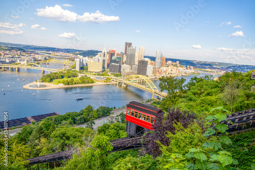 Red tram going down an incline in a city