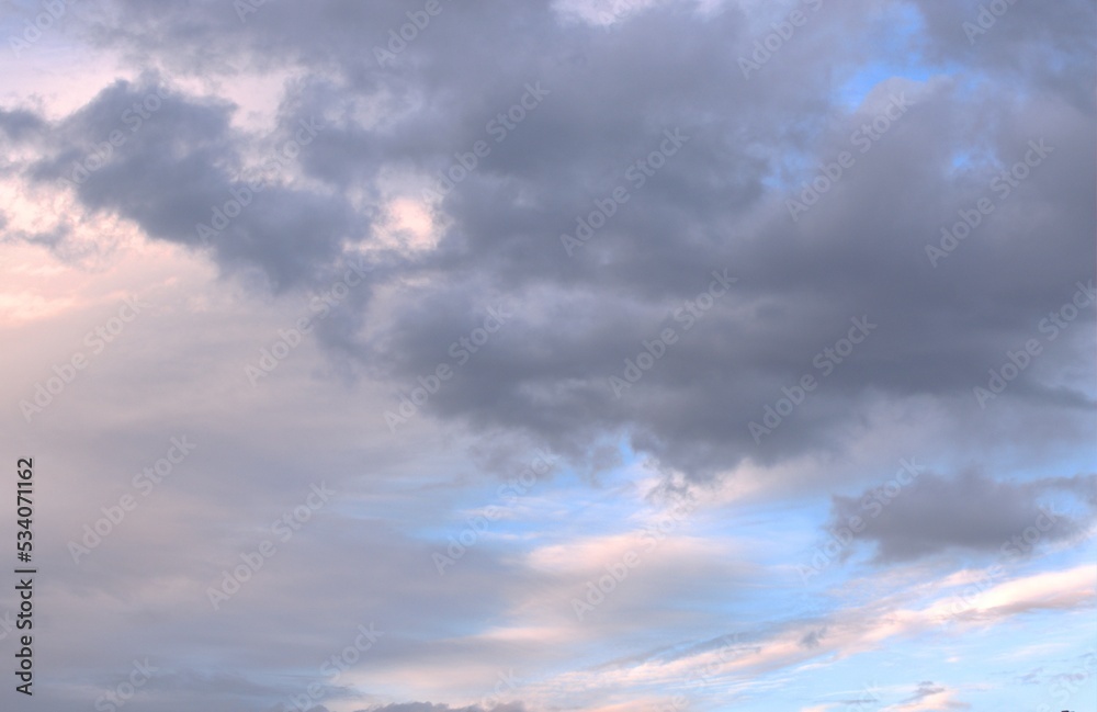 White and dark clouds float towards each other across the blue sky, on the monitor Background Banner Screensaver.
