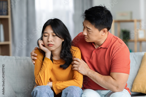 Loving asian husband comforting his upset wife