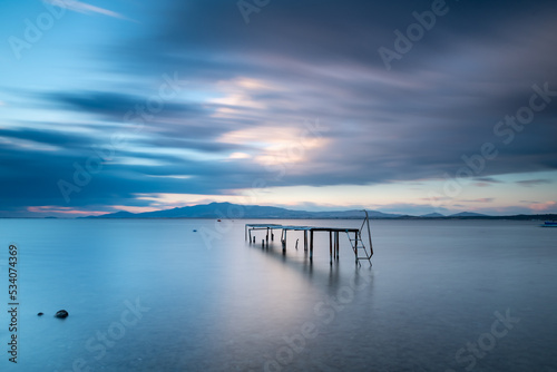 Wallpaper Mural Long exposure photography, wodden pier on foreground and silky sea water and colorful clouds on horizon as a background Torontodigital.ca
