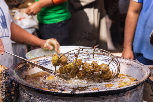 Vendor frying falafel balls in oil. photo