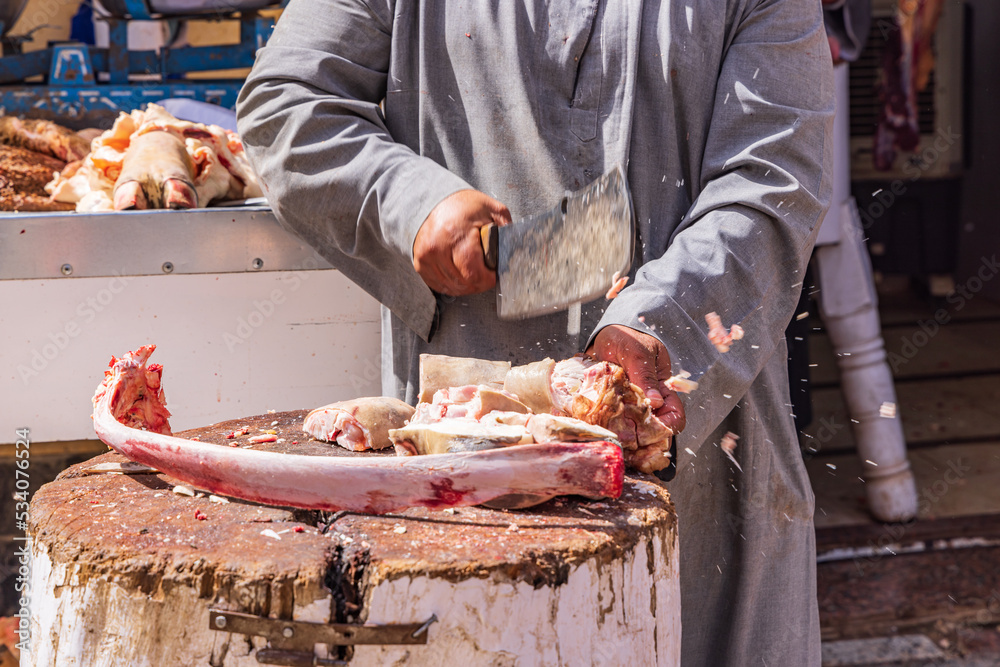 Chopping a cow foot on a butcher block in the street.