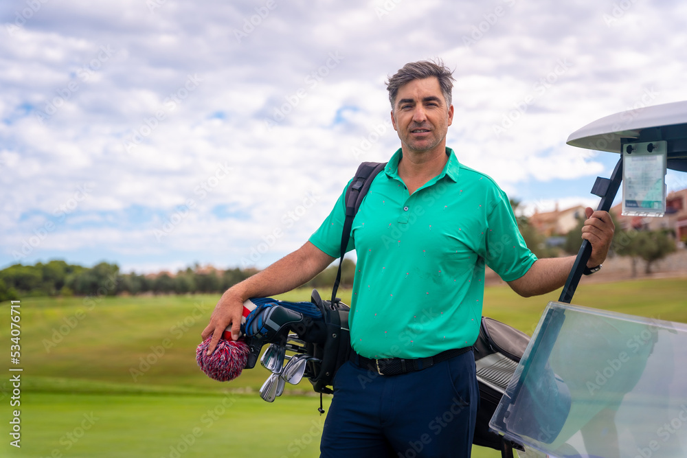 Portrait of a caucasian man playing golf next to the buggy on a cloudy day