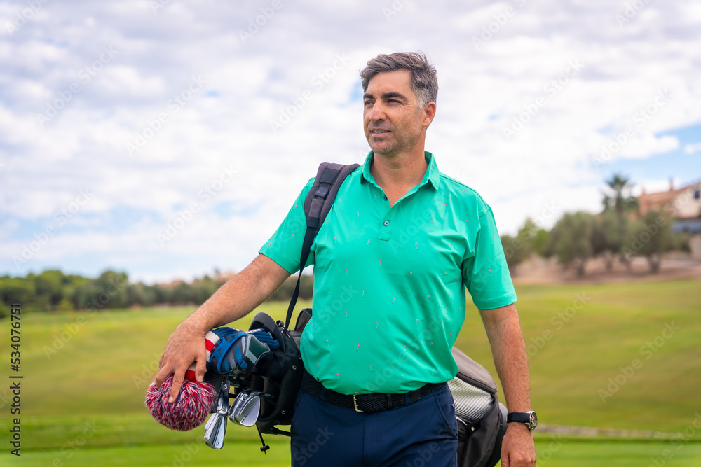Fototapeta premium A professional golf player on a golf course, walking towards the tee
