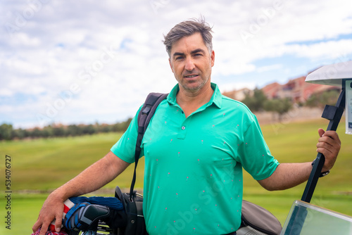 A professional golf player with the bag of clubs ready to play golf