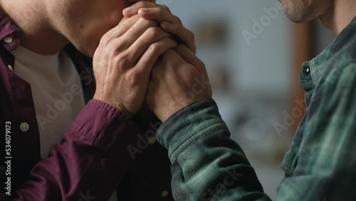 Authentic close up shot of mans hands gently kissed by his loving male partner. Touching moments of gay couple relationship holding and warming hands each other. GBTQ concept. High quality 4K footage