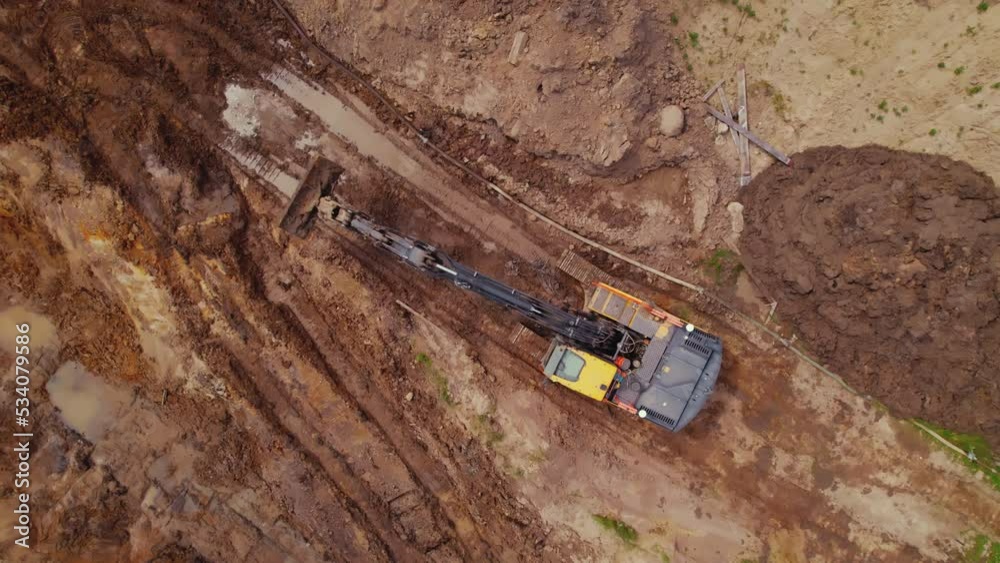 Earth-moving long-reach excavator digger working on a construction site in Warsaw, Poland. Aerial view. High quality 4k footage
