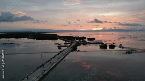 Aerial view: Motorbikes moving on the road pier in the Philippines at dusk.