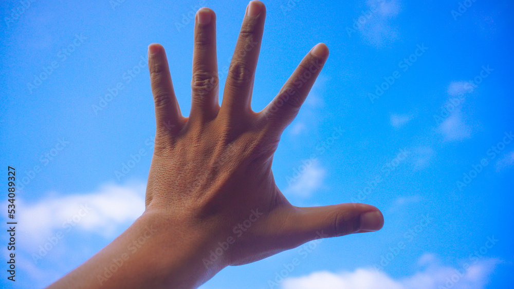 Male fist isolated on blue sky background. Asian hand make sign number 5. Counting, brave, masculinity concept Male fist isolated on blue sky background. Asian hand make sign number 5. Counting, brave, masculinity concept