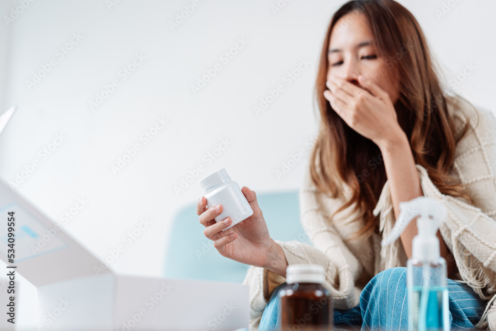 Asian young woman patient on eating table at nursing home care. Female look to medicine pills in bottle, read prescription and content. self recover health care concept. Asian young woman patient on eating table at nursing home care. Female look to medicine pills in bottle, read prescription and content. self recover health care concept.