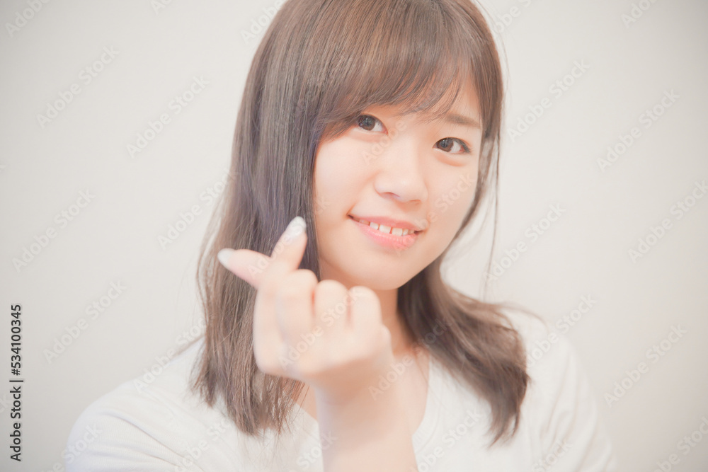 手でハートをつくる女性 手でハートをつくる女性