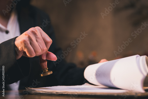 close-up of person stamping documents to approve agreements,