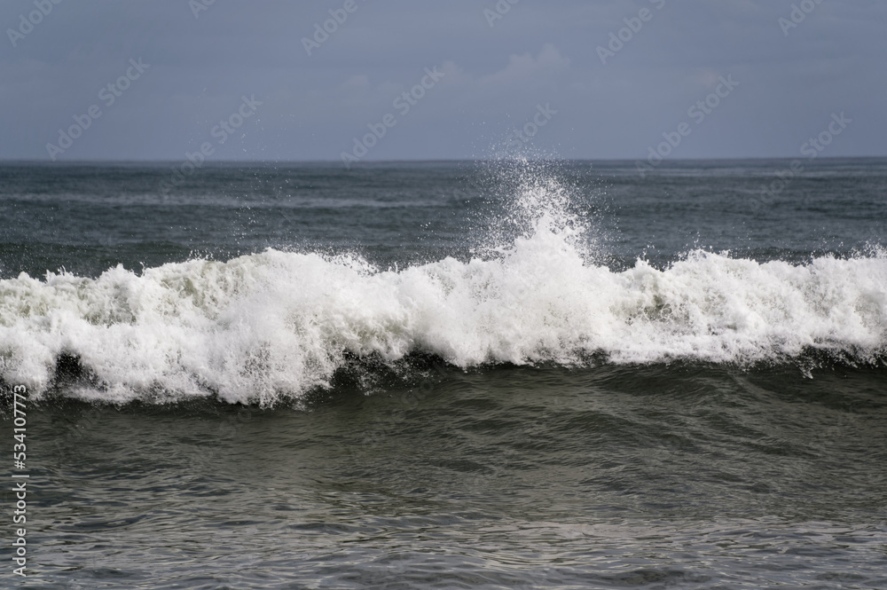 A wave breaks and tumbles to the shore