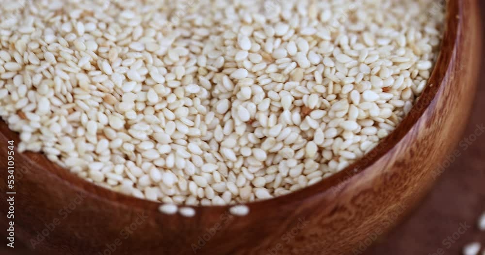 a bunch of white sesame seeds are spinning in a circle, more sesame seeds for cooking dishes and desserts a bunch of white sesame seeds are spinning in a circle, more sesame seeds for cooking dishes and desserts