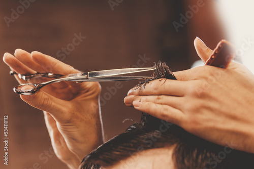 Barber shop concept, male hairdresser cutting hair with scissors, brown tinting vintage color