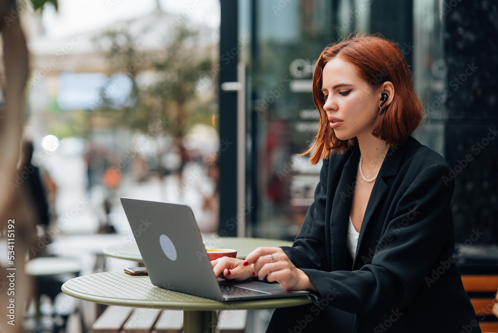 Beautiful woman working on laptop at outdoors cafe Beautiful woman working on laptop at outdoors cafe