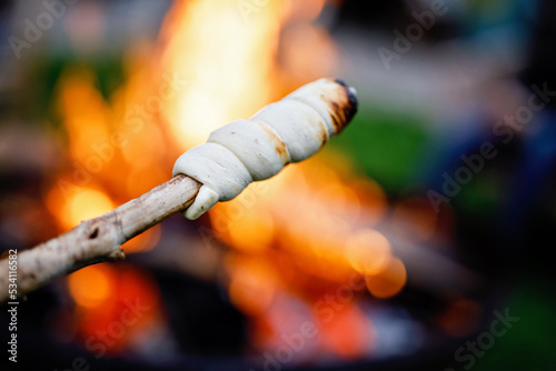 Stick bread twisted on skewer or stick, roasted on flame of fire. Popular party and camp barbecue food in Germany called Stockbrot. Fun for children. Healthy snack