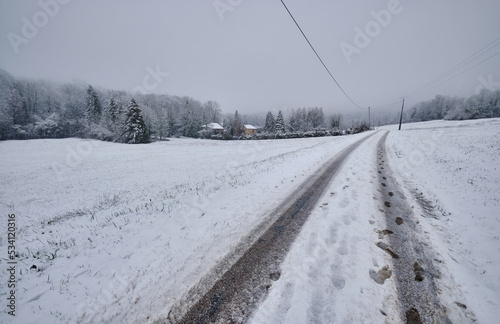 Route enneigée qui va en direction des petites maisons