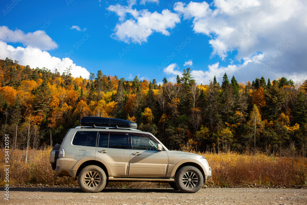 SUV on scenic autumn road in the forest SUV on scenic autumn road in the forest