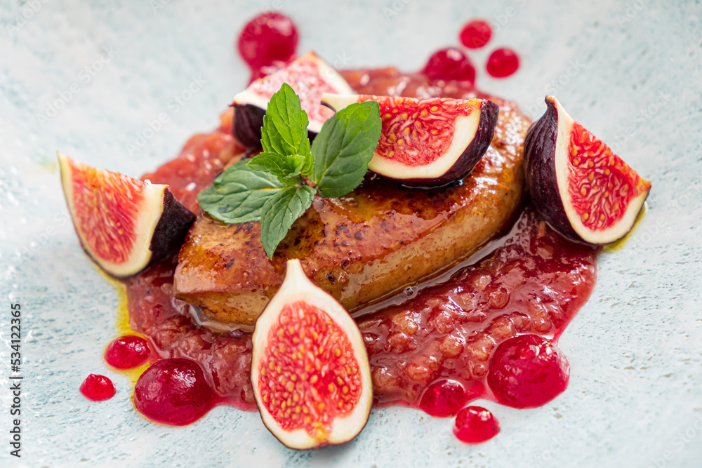 Rose roasted duck with fig  and drops of red wine sauce on a white plate, festive christmas dinner, copy space, high angle view from above, selected focus