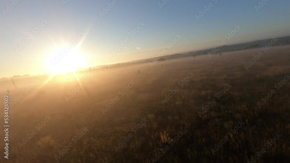 fpv drone flight in a field with white fog morning dawn sun humidity road where cars go fpv drone flight in a field with white fog morning dawn sun humidity road where cars go