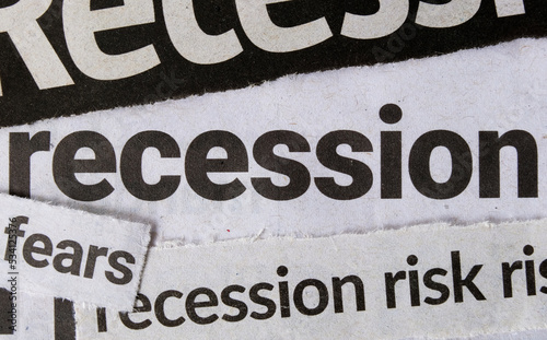 Economic recession dominating headline business news in major newspapers. Clippings of newspaper headline titles reporting on economic recession. Closeup macro view. photo