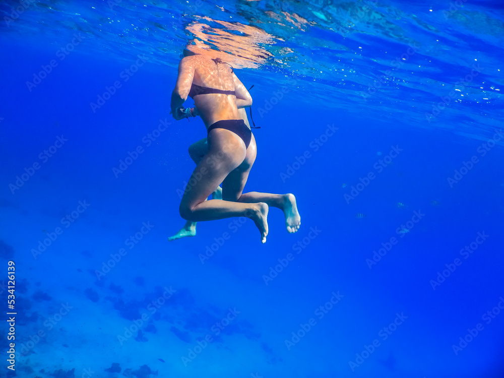 young beautiful girls hovering in deep blue water on vacation