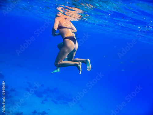 young beautiful girls hovering in deep blue water on vacation