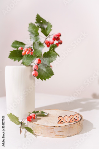 Minimal. Christmas background with a podium for a product presentation . The pedestal is made of natural wood with decorated. Happy New Year and Merry Christmas.