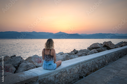 A woman looking at the sunset in Nafplio Athens Greece