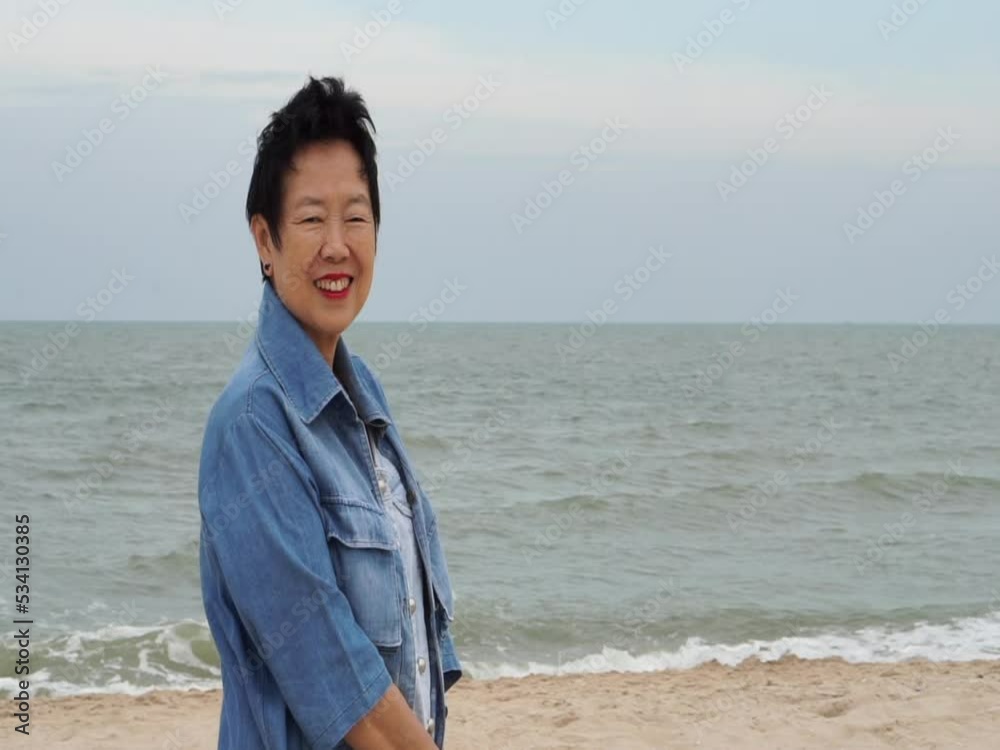 Cool stylish Asian senior woman smiling happy at beach nice fashion cloth Cool stylish Asian senior woman smiling happy at beach nice fashion cloth
