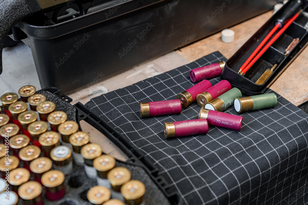 Shotgun shells on wooden table in a workshop Shotgun shells on wooden table in a workshop