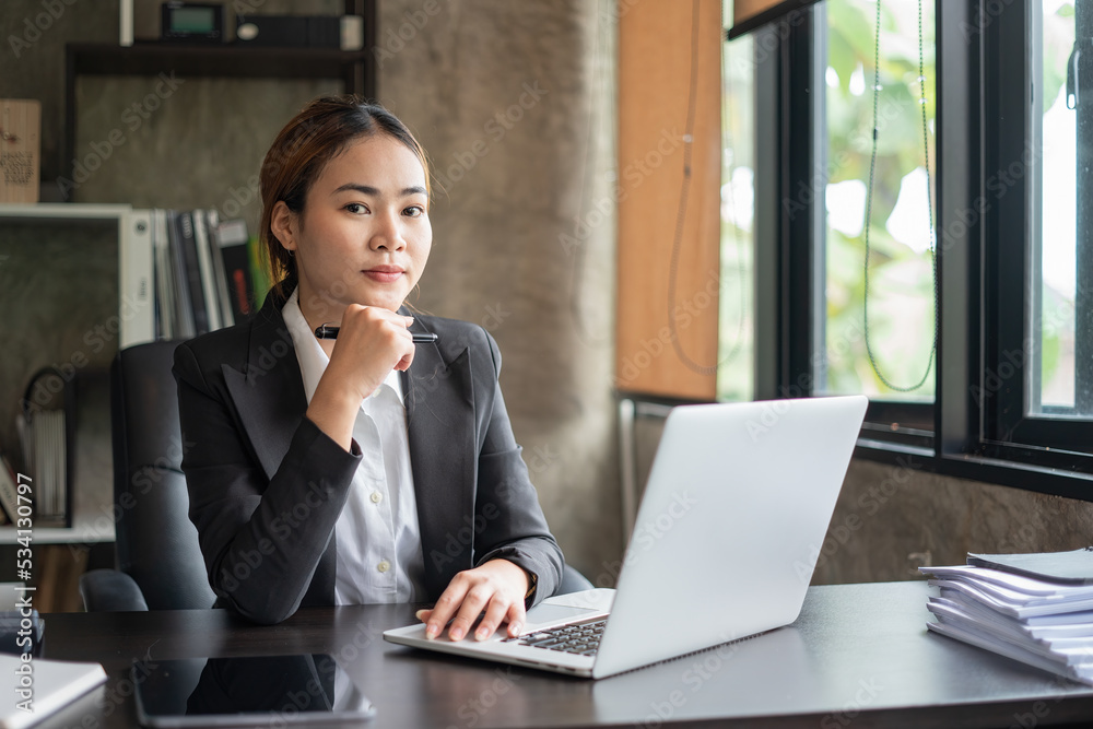 Asian woman working on a laptop computer, Working in the office with laptop concept, Young Asian woman starting a business using a laptop computer. Asian woman working on a laptop computer, Working in the office with laptop concept, Young Asian woman starting a business using a laptop computer.