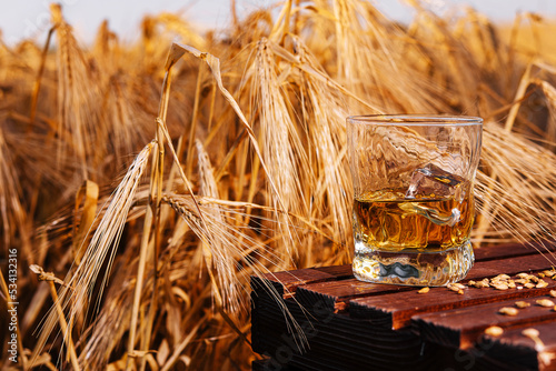 glass of whiskey in a field with ears