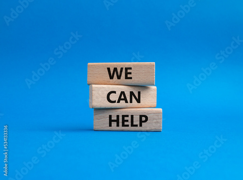 We can help symbol. Wooden blocks with words We can help. Beautiful blue background. Business and We can help concept. Copy space.