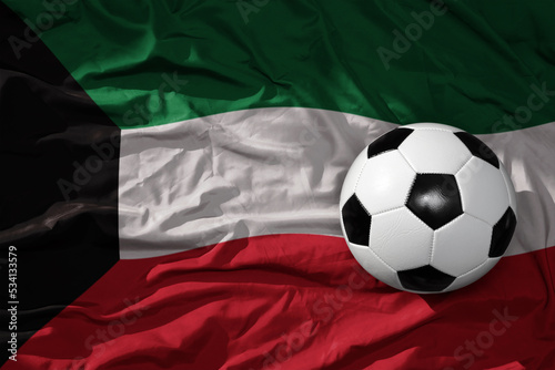 vintage football ball on the waveing national flag of kuwait background. 3D illustration