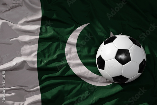 vintage football ball on the waveing national flag of pakistan background. 3D illustration
