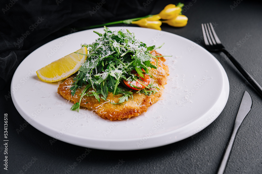 Traditional chicken schnitzel with arugula and lemon