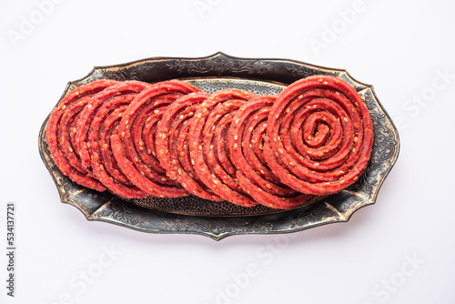 Beatroot chakli, murukku, Beetroot chakli, a spiral fried snack from India made in Diwali festival photo