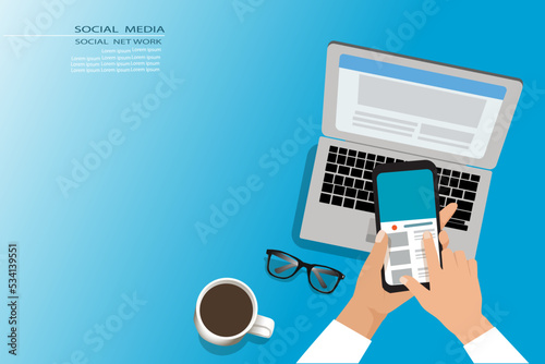 Social media, Social network concept.Hand holding the Mobile phone with laptop, eye glass and coffee cup on work place.