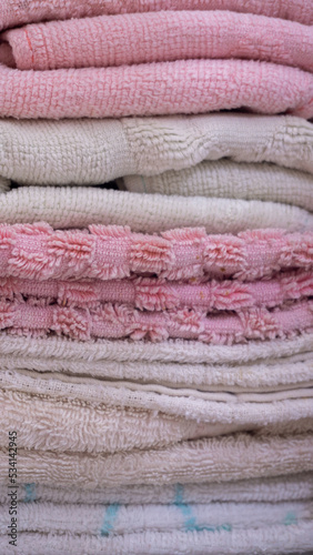 Pile of clean soft bath towels. Towels neatly folded in the shelf