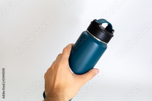 Man holding a blue thermos. white background.