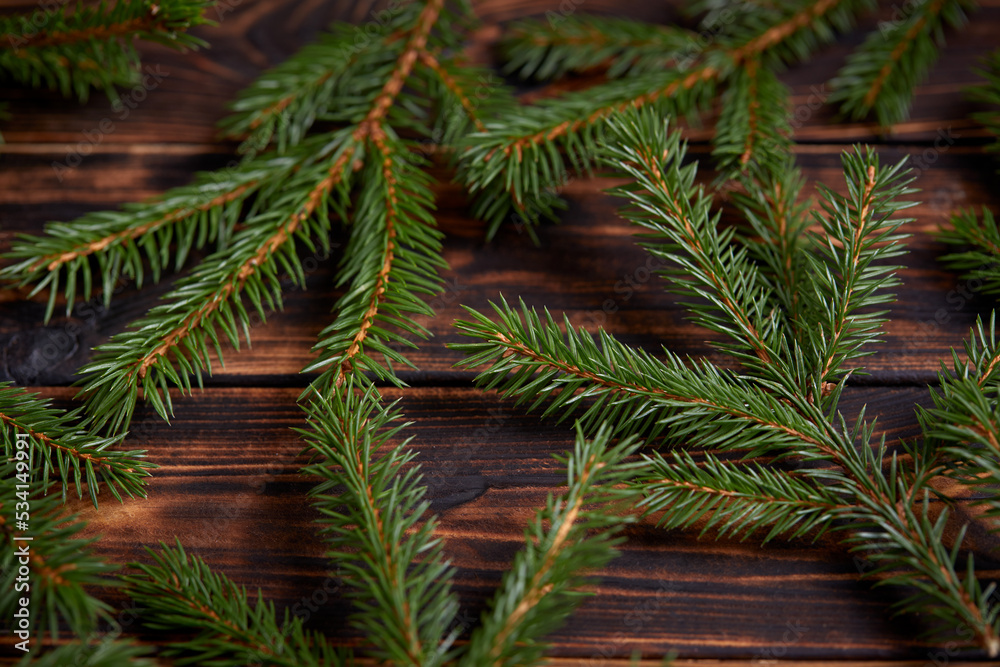 Christmas tree branches on the wooden background