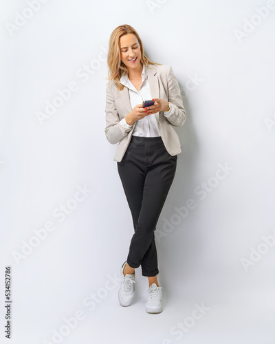 Canvastavla full body Beautiful young business woman by phone on white background