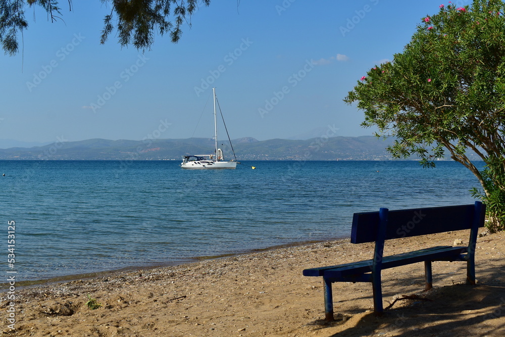 seascape with a yacht and a wooden bench on the shore seascape with a yacht and a wooden bench on the shore